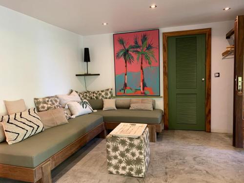 a living room with a couch and a green door at Hamakana gîte vue mer in Grand-Bourg