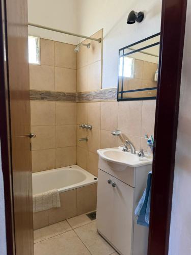a bathroom with a tub and a sink and a bath tub at Casa en Cabalango in Cavalango