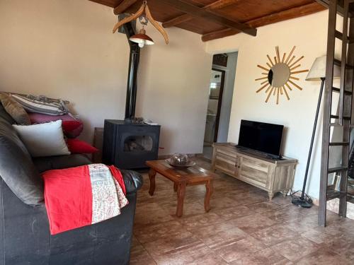 een woonkamer met een bank en een houtkachel bij Casa en Cabalango in Cavalango