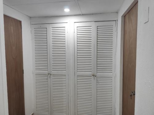 a closet with white shutter doors in a room at Apartment on Margarita Island edif Lagunablanca Apto 1201 in Porlamar