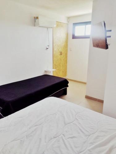 a bedroom with a bed and a window and a door at Nuestras raíces 1 in Villa Carlos Paz