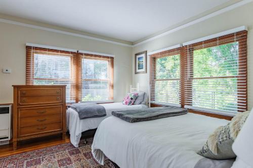 two twin beds in a bedroom with windows at 4 Berkeley Furnished Apartment - 2 Beds Laundry and Parking in Berkeley