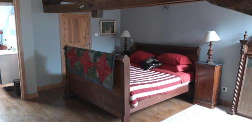 ein Schlafzimmer mit einem Bett mit roten Kissen in der Unterkunft La Belle Maison in Piégut-Pluviers
