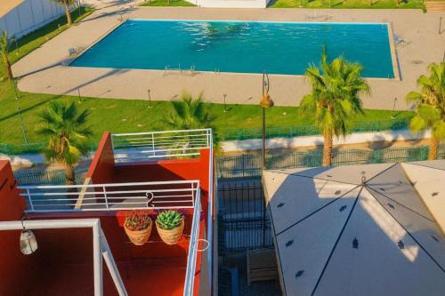 eine Draufsicht auf einen Swimmingpool mit Palmen in der Unterkunft Riad Imperial Atlas in Meknès