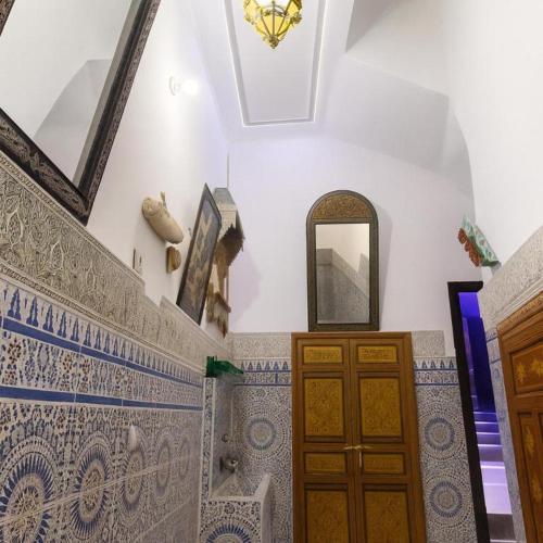 a room with blue and white tiles and a mirror at Riad Imperial Atlas in Meknès