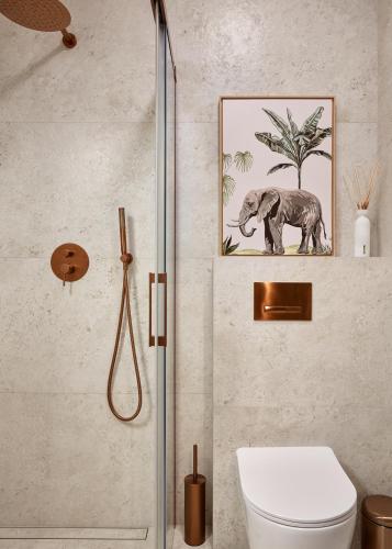 a bathroom with a toilet and a picture of an elephant at Apartament Hugo - Stare Miasto - Garaż Gratis !!! in Elblag