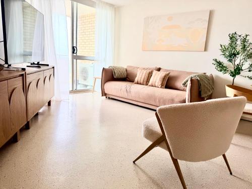 a living room with a couch and a chair at 706TheSands Beachfront Apartment at the centre of Surfers Paradise in Gold Coast