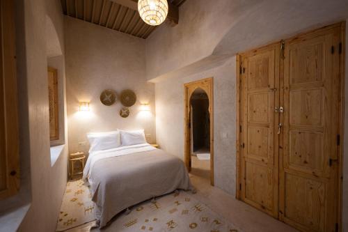 a bedroom with a bed and a chandelier at Riad le myrath in Essaouira