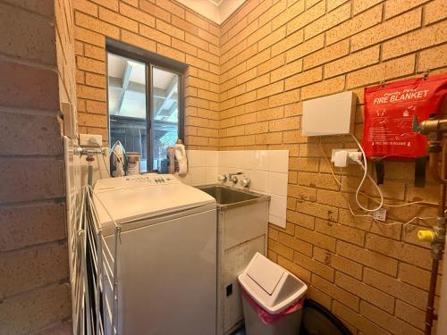 Una pequeña cocina con fregadero y refrigerador. en Tropic Oasis by Charlesworth, en Coffs Harbour