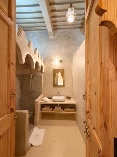a bathroom with a sink and a shower and a mirror at Riad le myrath in Essaouira