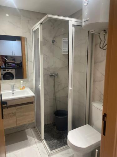een badkamer met een douche, een toilet en een wastafel bij Résidence Picasso in Casablanca