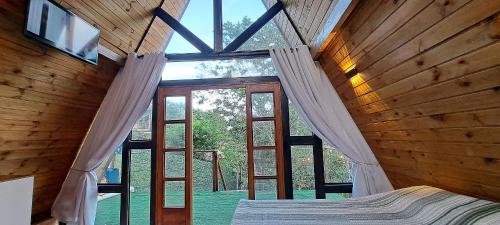 ein Schlafzimmer mit einem Bett und einem großen Fenster in der Unterkunft Chalé em Morro de São Paulo in Cayru