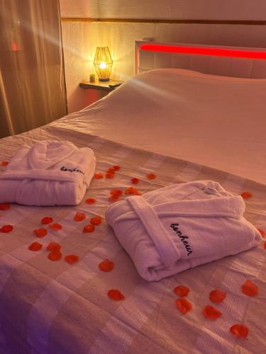two towels on a bed with hearts on it at Nali Room in La Vespière