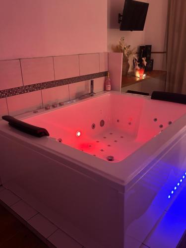 Nali Room في La Vespière: حوض استحمام كبير مزود بإضاءة حمراء في غرفة