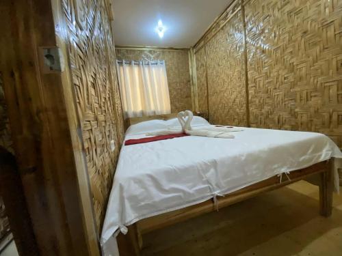 Un dormitorio pequeño con una cama con sábanas blancas. en The Tribe Apartment, en Port Barton