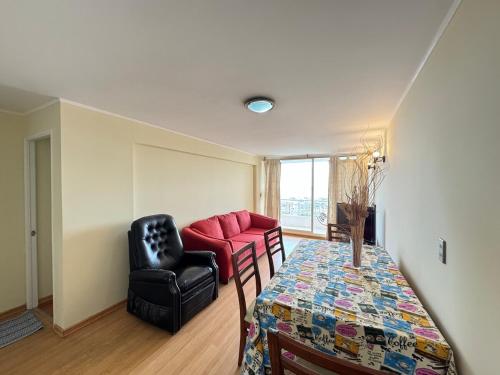 ein Wohnzimmer mit einem Tisch und einer roten Couch in der Unterkunft Excellent apartment, view and quiet atmosphere in Viña del Mar