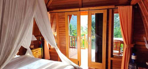 a bedroom with a bed and a glass door at Kastawa Villa in Sidemen