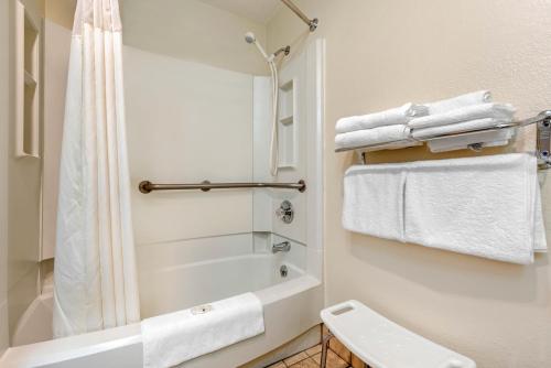 a bathroom with a shower and a toilet and towels at 1734 West Hotel in Fort Wayne