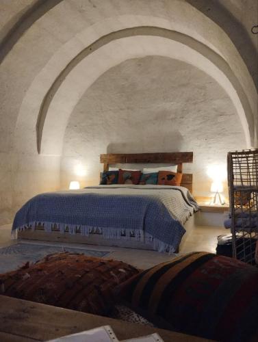 a bedroom with a large bed in a stone wall at Route Cappadocia in Avanos