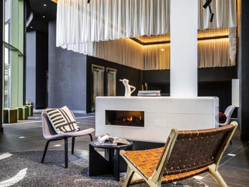 vestíbulo con 2 sillas y chimenea en Tribe Amsterdam City, en Ámsterdam