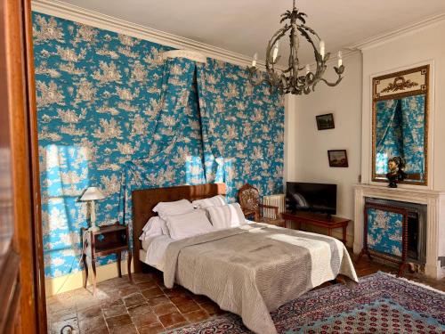 ベレームにあるChâteau des Feugeretsのベッドルーム1室(青い花の壁紙のベッド1台付)