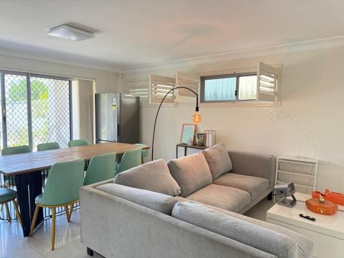 a living room with a couch and a table at Urban Silver Haven Sleek stay - 1 Min to Station With TV projector Game space and high speed internet - Shared bathroom with ONLY ONE other room in Sydney
