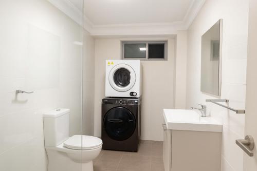 シドニーにあるUrban Silver Haven Sleek stay - 1 Min to Station With TV projector Game space and high speed internetのバスルーム(トイレ、洗濯機付)