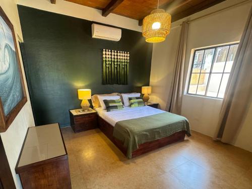 una camera da letto con un letto e una parete verde di Dos Palmas a El Sunzal