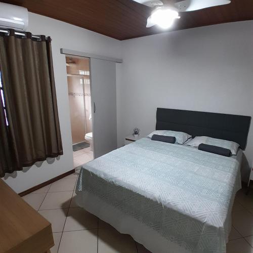 una camera da letto con un letto grande e una finestra di Flat luxo e tranquilidade a Volta Redonda