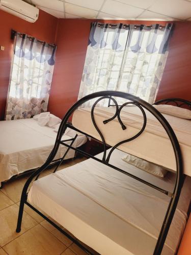 two bunk beds in a room with windows at Villalobos Hotel Managua in Managua
