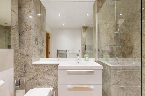 a bathroom with a white sink and a shower at Khayat Homes - The Ford in Chelmsford