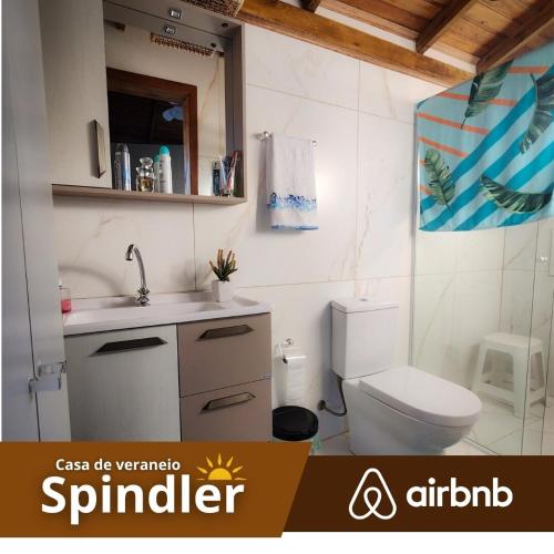 a bathroom with a white toilet and a sink at Spindler summer house in Tramandaí