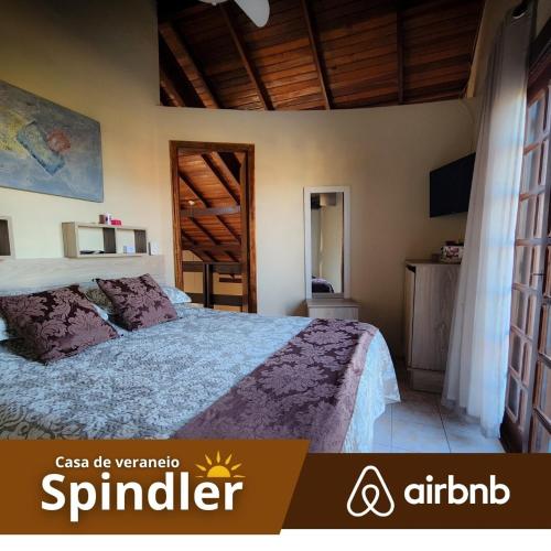 a bedroom with a bed and a wooden ceiling at Spindler summer house in Tramandaí