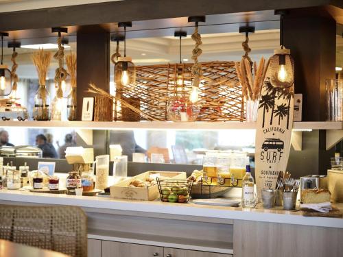 um restaurante com um balcão com comida em ibis Styles Bordeaux Begles Arena em Bègles