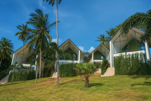 een gebouw met palmbomen ervoor bij Sumba Luxury Cottages Pool & Jacuzzi in Ko Pha Ngan