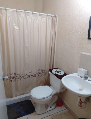 a bathroom with a toilet and a sink at Departamento Morrocoy Ixtapa in Ixtapa