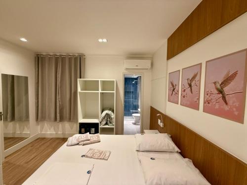 a bedroom with a large bed with white sheets at Hotel Sheik Business in Rio de Janeiro