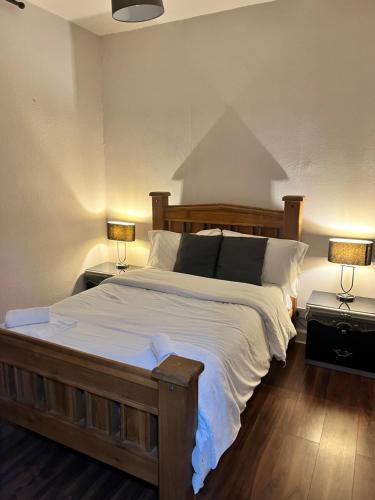 a bedroom with a large bed with two lamps at Royal Apartments Edinburgh in Edinburgh