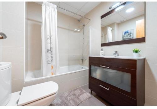 a bathroom with a tub and a toilet and a sink at Apartamentos de Miguel in Vinebre