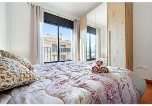 a bedroom with a large bed with a large window at Apartamentos de Miguel in Vinebre