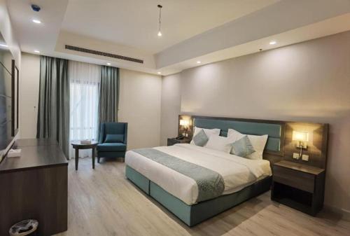 een hotelkamer met een bed en een stoel bij شقق عائلتي - My family's apartments in Jeddah