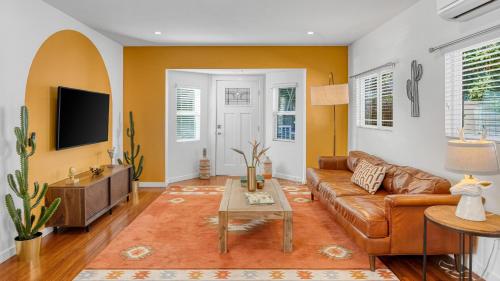a living room with a brown couch and a tv at Southwest by AvantStay in Los Angeles