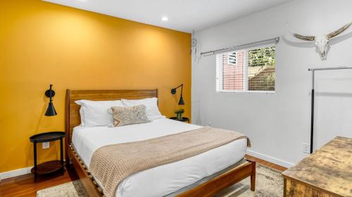 a bedroom with a bed and a yellow wall at Southwest by AvantStay in Los Angeles