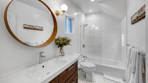 a bathroom with a sink and a toilet and a mirror at Southwest by AvantStay in Los Angeles
