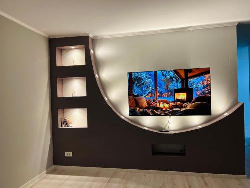 a living room with a flat screen tv on a wall at City View Apartment in Mitrovicë
