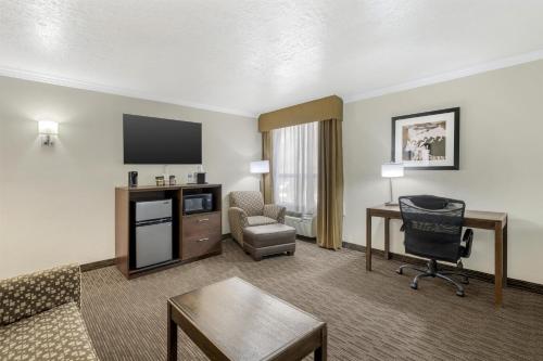 a living room with a couch and a chair and a desk at Best Western Airport Albuquerque InnSuites Hotel & Suites in Albuquerque