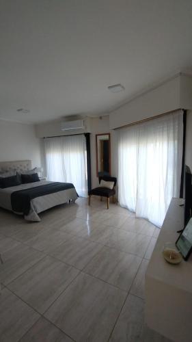 a bedroom with a bed and a chair in a room at Terra Apart in Chivilcoy
