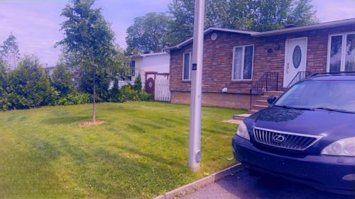 ein Auto, das auf einem Hof vor einem Haus parkt in der Unterkunft Amazing Home away from Home in Sainte-Catherine