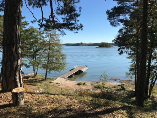 a dock in the middle of a lake with trees at Old Hospital & Sauna at the Beach in Pargas