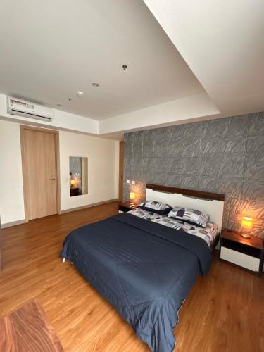 a bedroom with a large bed and two lamps at Fairview House apartment karawaci in Karawaci